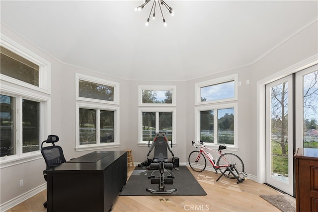 office area with light hardwood / wood-style floors and a notable chandelier