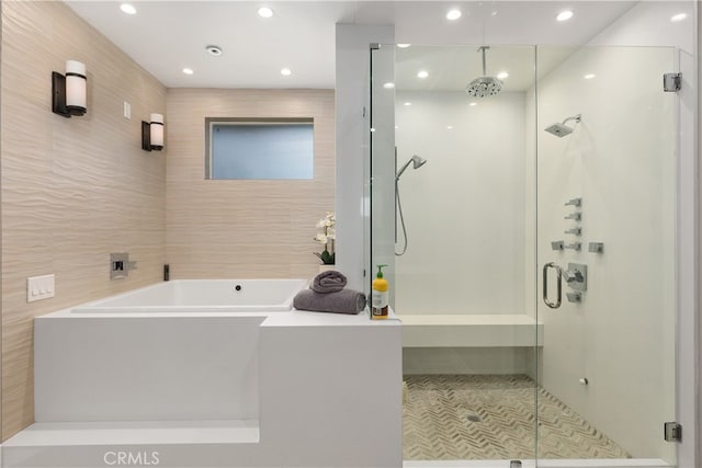 bathroom with independent shower and bath and tile walls