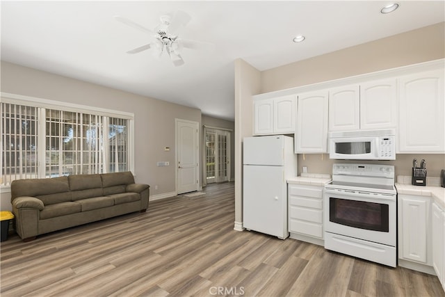 kitchen with white cabinets, light hardwood / wood-style flooring, ceiling fan, and white appliances