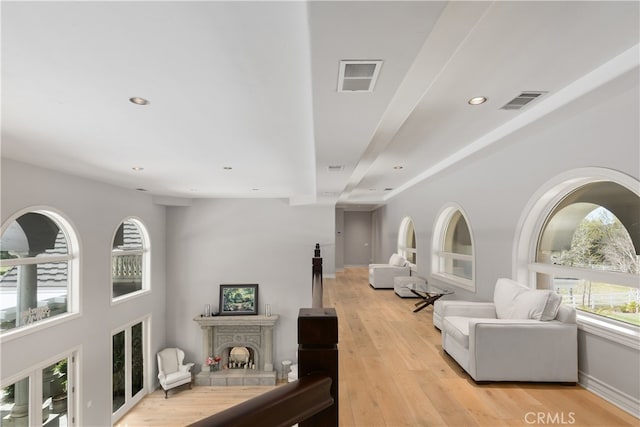 living room with light hardwood / wood-style floors and a tile fireplace