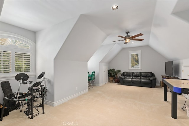 interior space with ceiling fan, lofted ceiling, a wealth of natural light, and light carpet