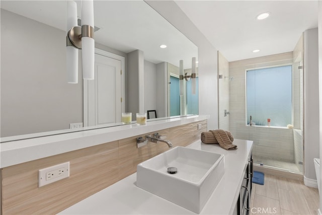 bathroom featuring vanity, tiled shower, and tile floors