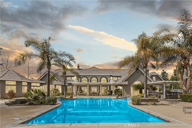 pool at dusk with a patio