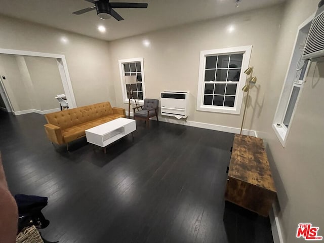 living room with heating unit, wood-type flooring, and ceiling fan