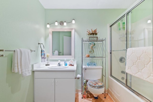 bathroom featuring combined bath / shower with glass door, hardwood / wood-style floors, and vanity