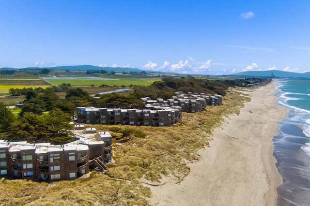 drone / aerial view featuring a water and mountain view and a view of the beach