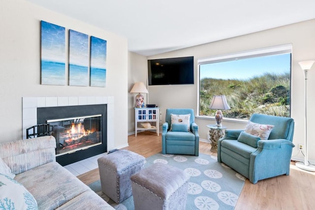 living room with light hardwood / wood-style floors and a tile fireplace