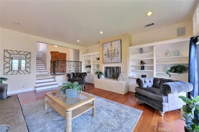 living room with dark wood-type flooring and built in shelves