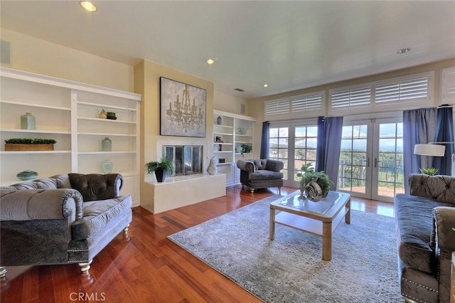 living room with dark hardwood / wood-style flooring, french doors, and built in features