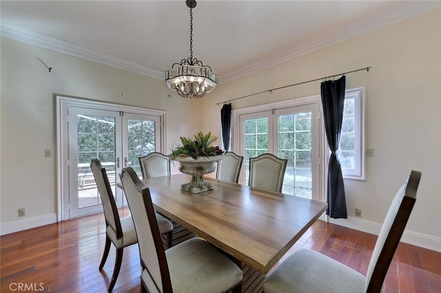 dining area with dark hardwood / wood-style flooring, ornamental molding, an inviting chandelier, and french doors