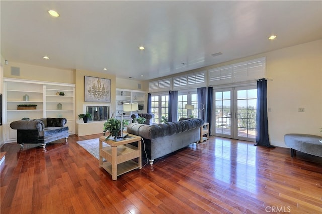 living room featuring french doors, dark hardwood / wood-style flooring, and built in shelves