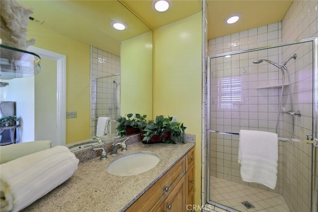 bathroom featuring walk in shower and vanity with extensive cabinet space