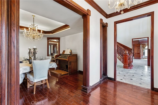 dining space featuring ornamental molding, dark wood-type flooring, and an inviting chandelier