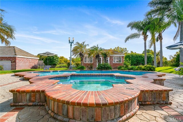 view of swimming pool with a patio area and an in ground hot tub