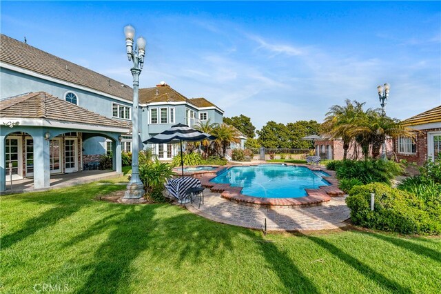 view of pool featuring a patio area and a yard