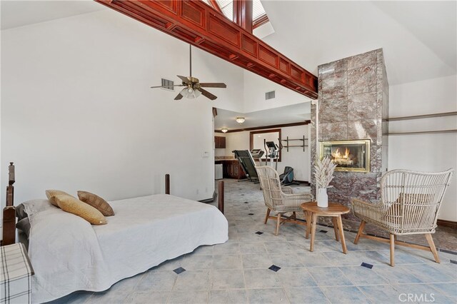 bedroom featuring light tile patterned floors, high vaulted ceiling, ceiling fan, and a tiled fireplace