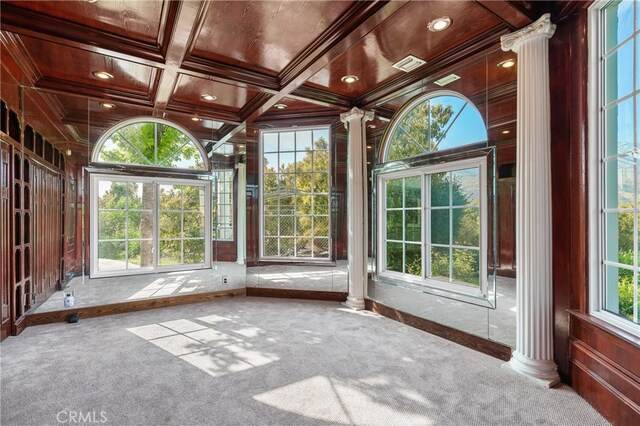 unfurnished sunroom with coffered ceiling, a wealth of natural light, and decorative columns