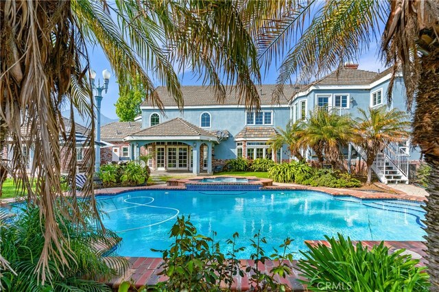 view of swimming pool with an in ground hot tub