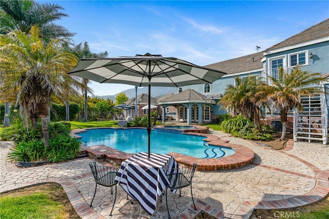 view of pool featuring a patio area and an in ground hot tub