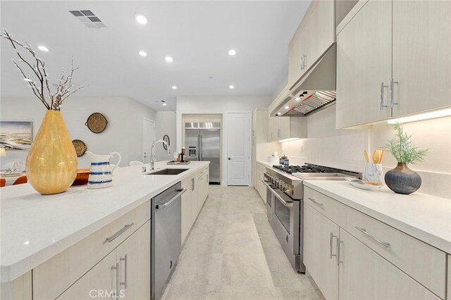 kitchen featuring light tile floors, high end appliances, and sink