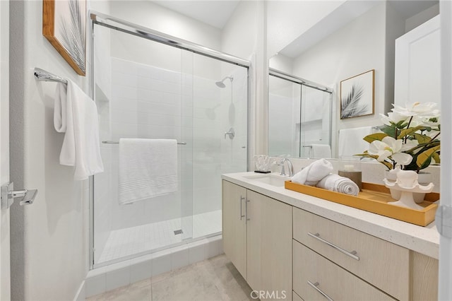 bathroom with walk in shower, vanity, and tile flooring