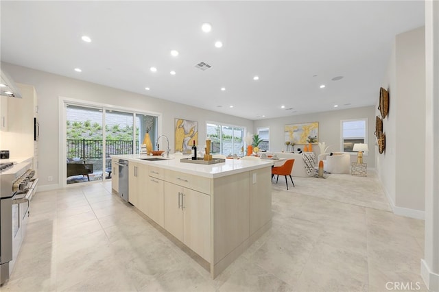 kitchen featuring light tile floors, a kitchen island with sink, sink, and stainless steel appliances