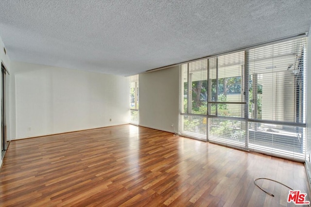 spare room featuring a textured ceiling and wood-type flooring