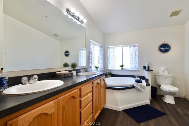 bathroom with dual vanity, toilet, hardwood / wood-style flooring, and a bathtub