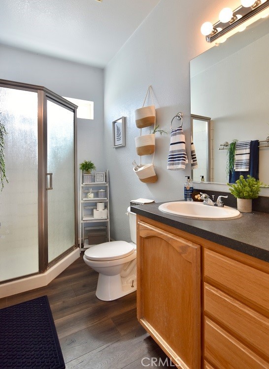 bathroom with vanity, an enclosed shower, wood-type flooring, and toilet