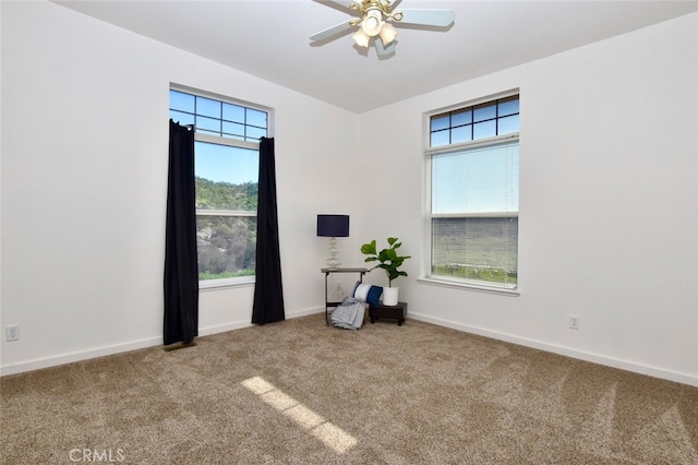 carpeted empty room featuring ceiling fan and a wealth of natural light