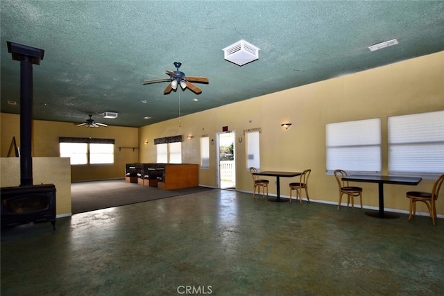 garage with ceiling fan and a wood stove