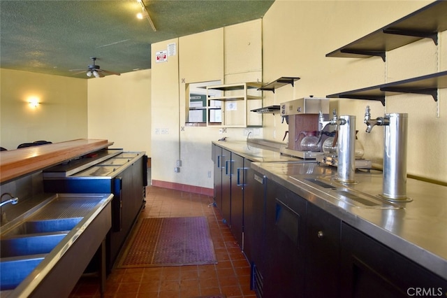 kitchen featuring stainless steel counters, white cabinetry, rail lighting, a textured ceiling, and ceiling fan