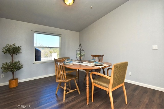 dining area with dark hardwood / wood-style flooring and vaulted ceiling