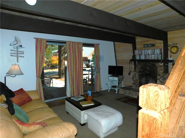 living room featuring beam ceiling and a stone fireplace