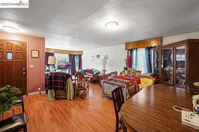 dining room with hardwood / wood-style floors and a textured ceiling