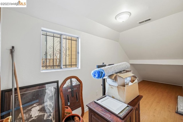 office with vaulted ceiling and light hardwood / wood-style flooring