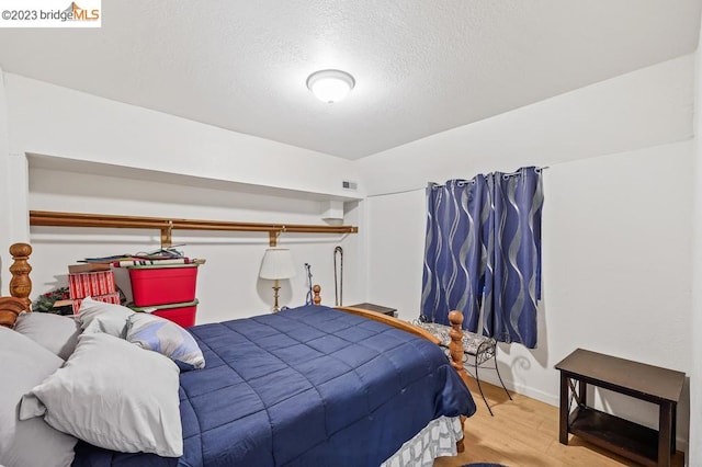 bedroom featuring light wood-type flooring and a textured ceiling