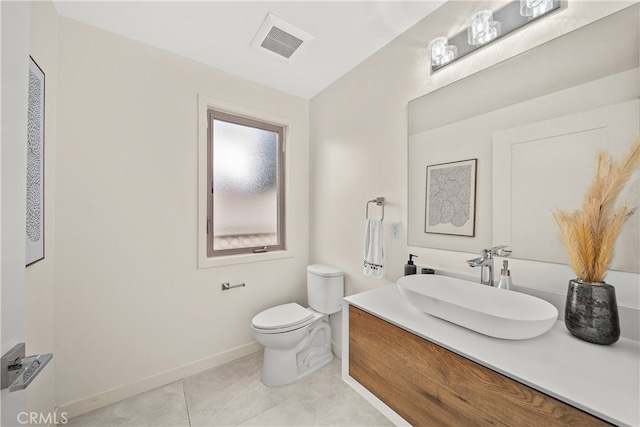 bathroom featuring toilet, vanity, and tile flooring