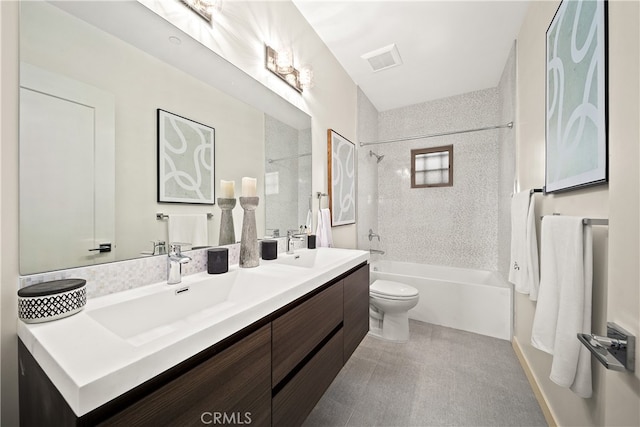 full bathroom featuring tile floors, dual sinks, tiled shower / bath, vanity with extensive cabinet space, and toilet