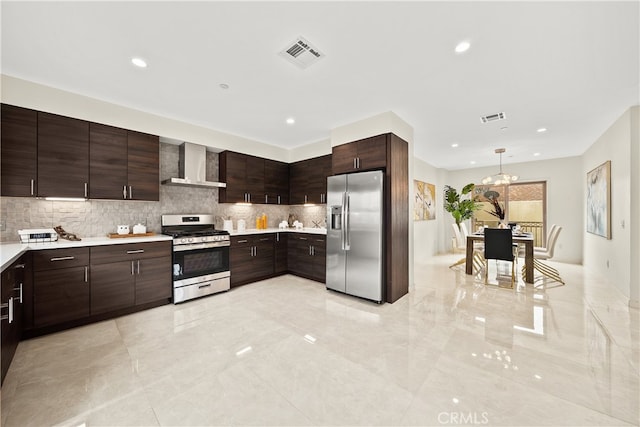 kitchen featuring hanging light fixtures, backsplash, stainless steel appliances, light tile flooring, and wall chimney range hood