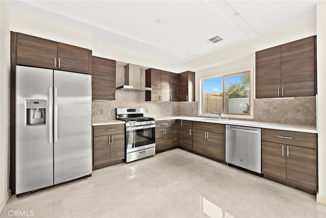 kitchen with backsplash, appliances with stainless steel finishes, sink, light tile floors, and wall chimney exhaust hood