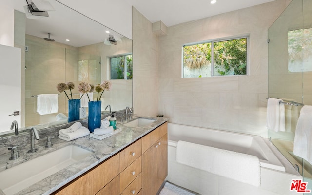 bathroom with a tile shower and vanity