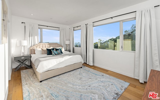 bedroom featuring light wood-type flooring and multiple windows