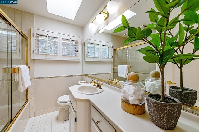 bathroom with toilet, a skylight, and large vanity