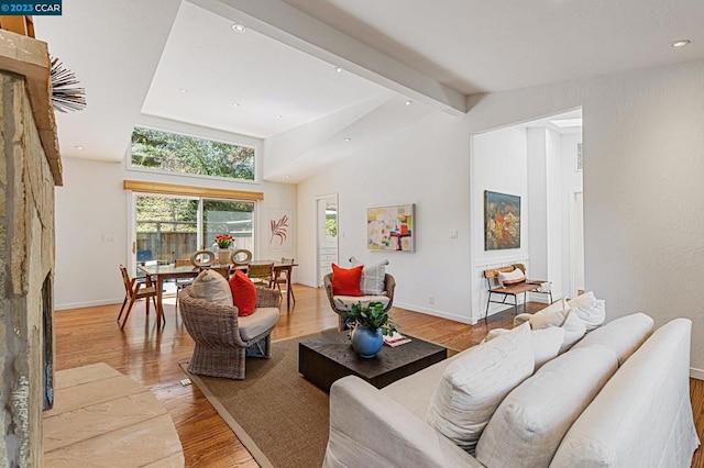 living room with high vaulted ceiling, beam ceiling, and light wood-type flooring