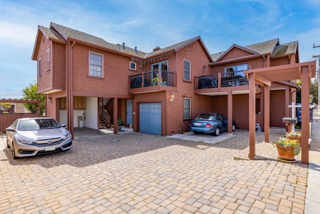 view of front of property featuring a garage and a balcony