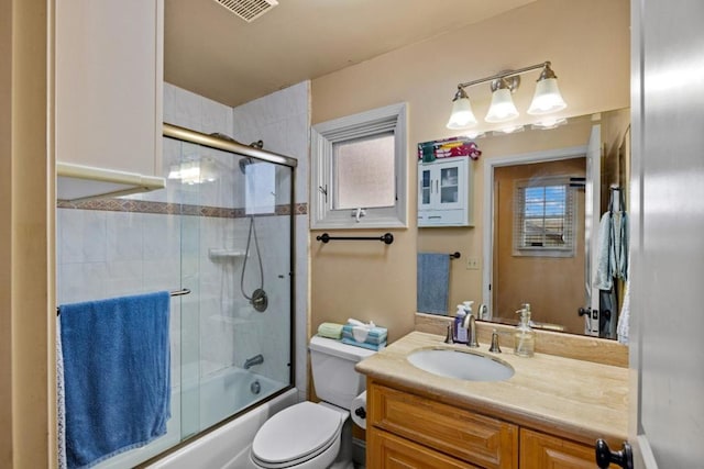 full bathroom featuring vanity, toilet, and enclosed tub / shower combo