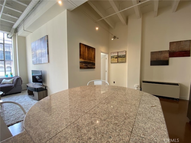 kitchen featuring a high ceiling and beamed ceiling