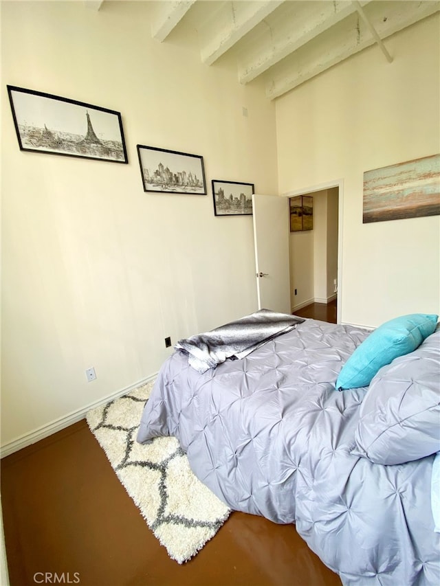 carpeted bedroom with beamed ceiling