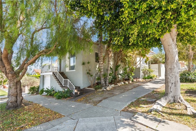 view of front of property with stairs and stucco siding